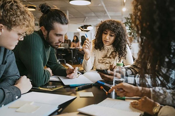 Students studying together at table in cafeteria